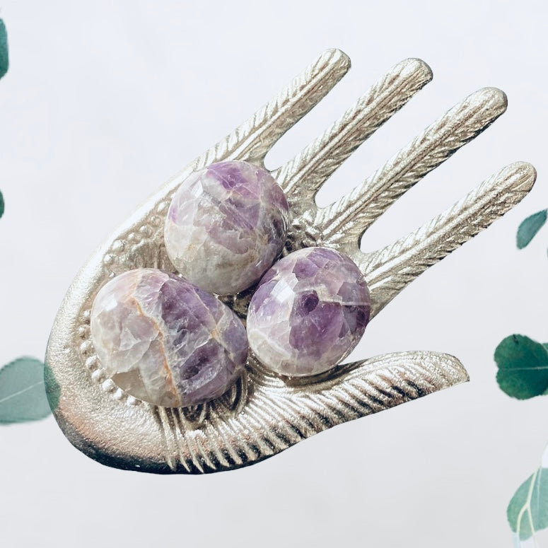Evermore Everlasting amethyst palm stone showing a polished purple crystal with smooth, rounded edges for meditation or display.