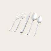 Italic Emilia Mirror 20-piece flatware set with sleek silver finish, including forks, knives, spoons, and serving utensils.