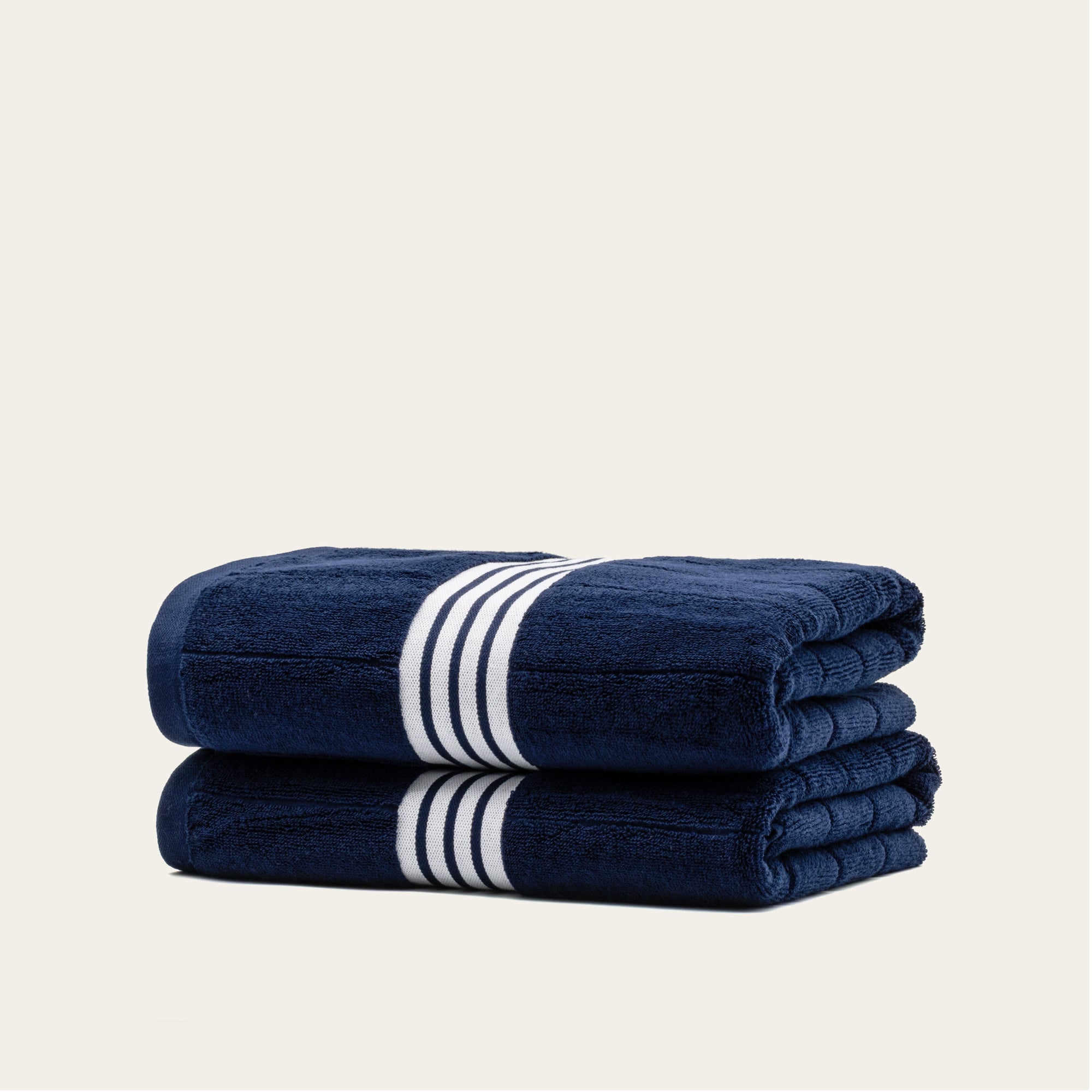 Nautilus Australian Cotton Bath Towel by Italic, soft and plush with white and light blue stripes, displayed on a bathroom hook.