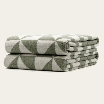 Italic Umbra Australian Cotton Bath Towels, soft and plush, shown folded on a bathroom shelf in natural lighting.