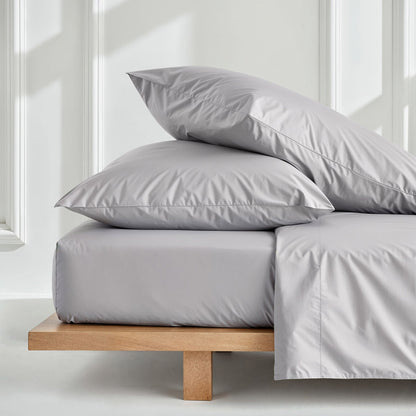 Luxe Australian sateen pillowcase set by Italic featuring smooth, shiny fabric and elegant stitching on a bed.