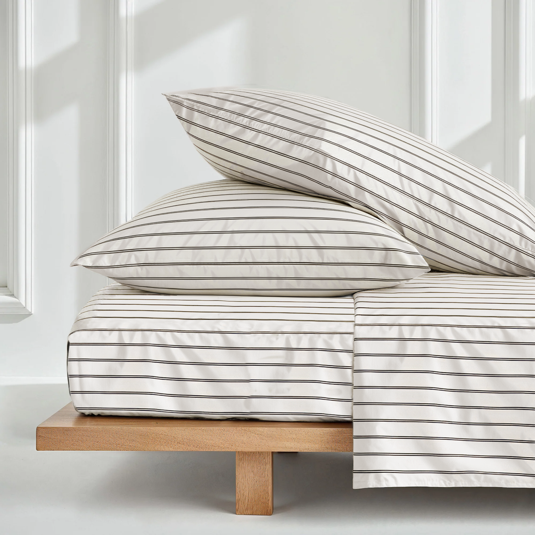 Black and ecru mini stripe satin sheet set by Italic, showcasing smooth, luxurious Australian sateen bed sheets on a neatly made bed.