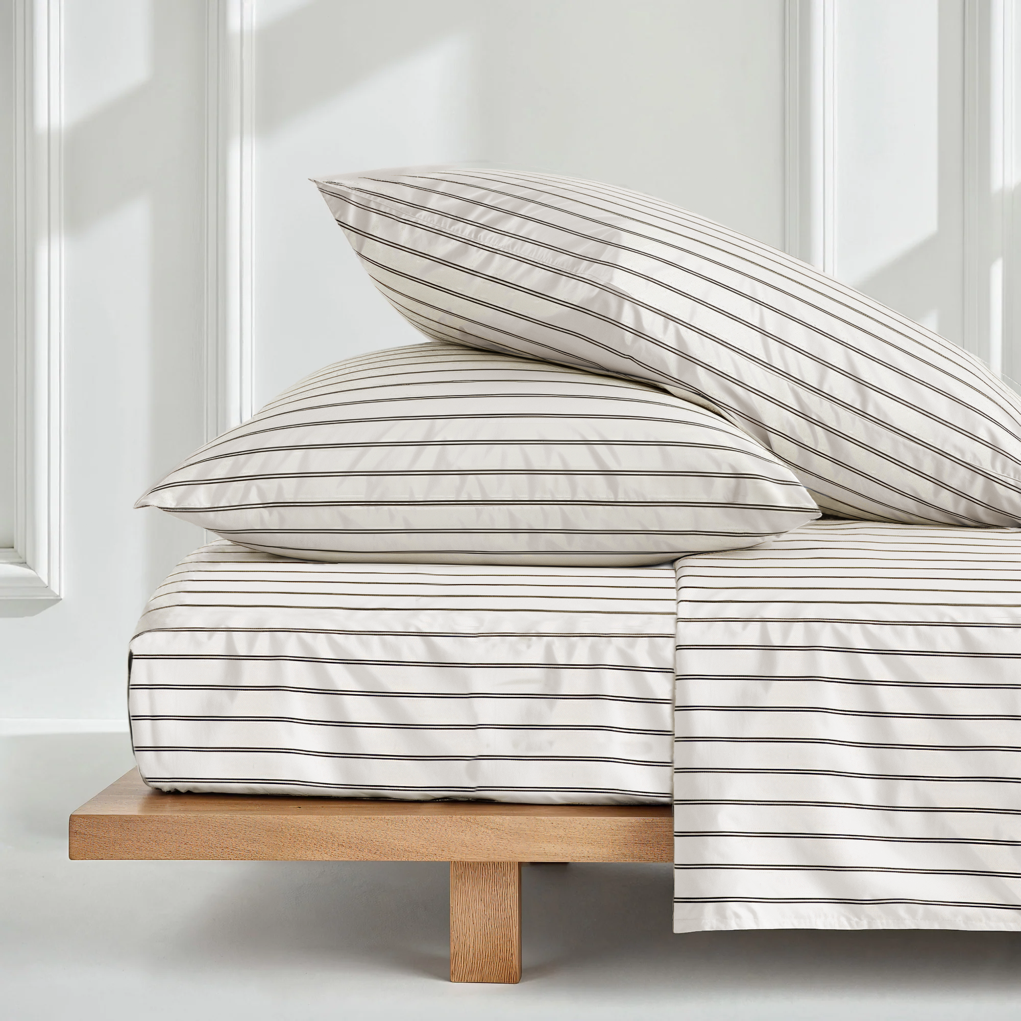 Black and ecru mini stripe satin sheet set by Italic, showcasing smooth, luxurious Australian sateen bed sheets on a neatly made bed.