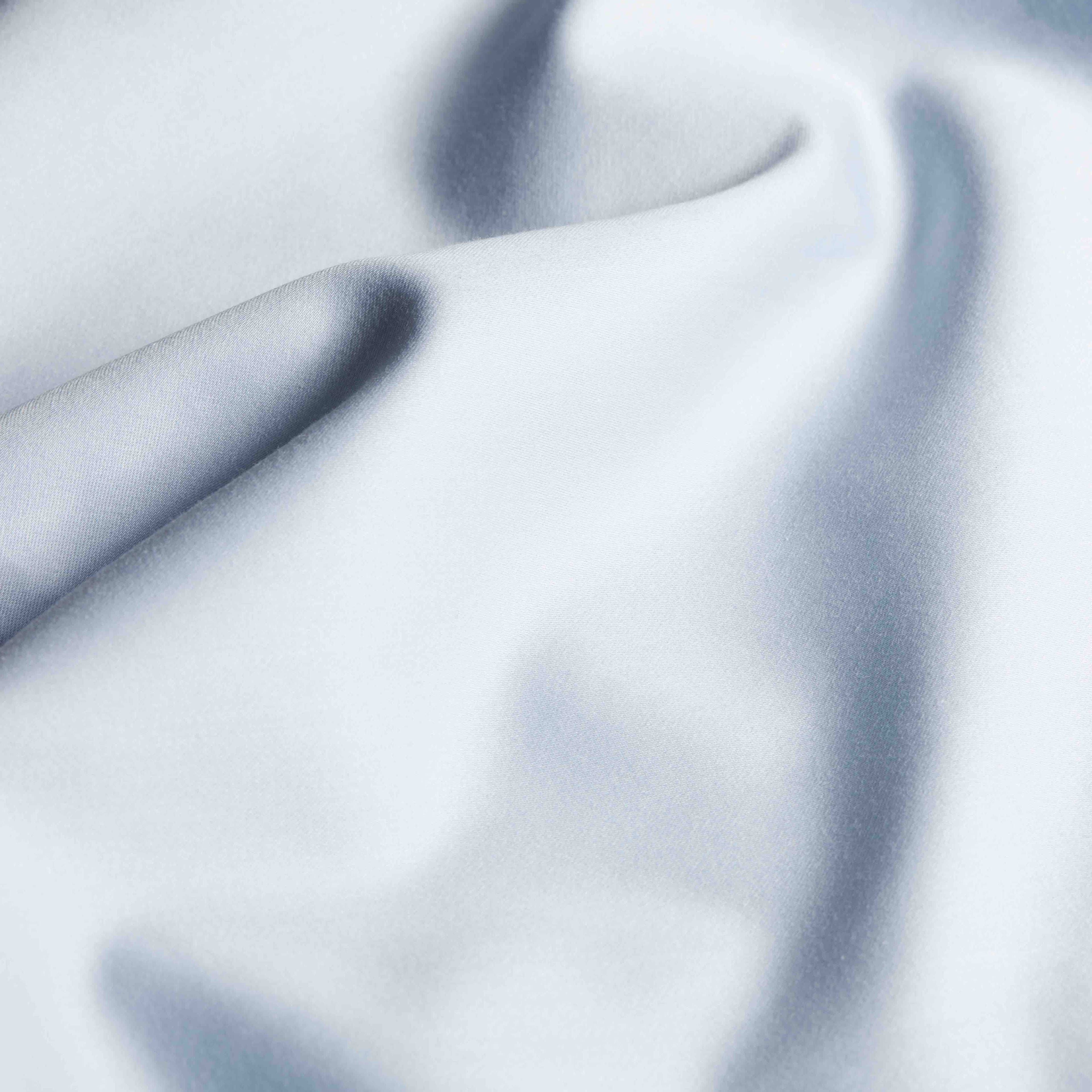 Soft Luxe Australian Sateen Sheet Set by Italic on a bed with smooth, shiny satin fabric in a cozy bedroom setting.