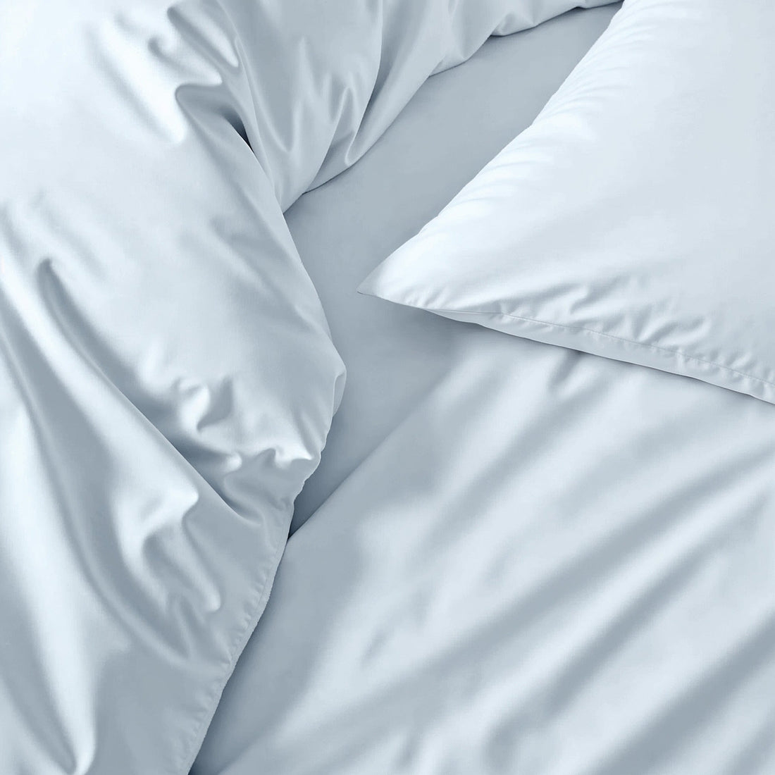 Soft white Luxe Australian Sateen Sheet Set from Italic on a neatly made bed with smooth, shiny satin fabric for a luxurious sleep.