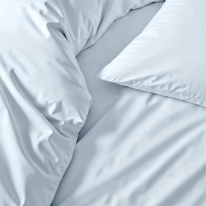 Soft white Luxe Australian Sateen Sheet Set from Italic on a neatly made bed with smooth, shiny satin fabric for a luxurious sleep.