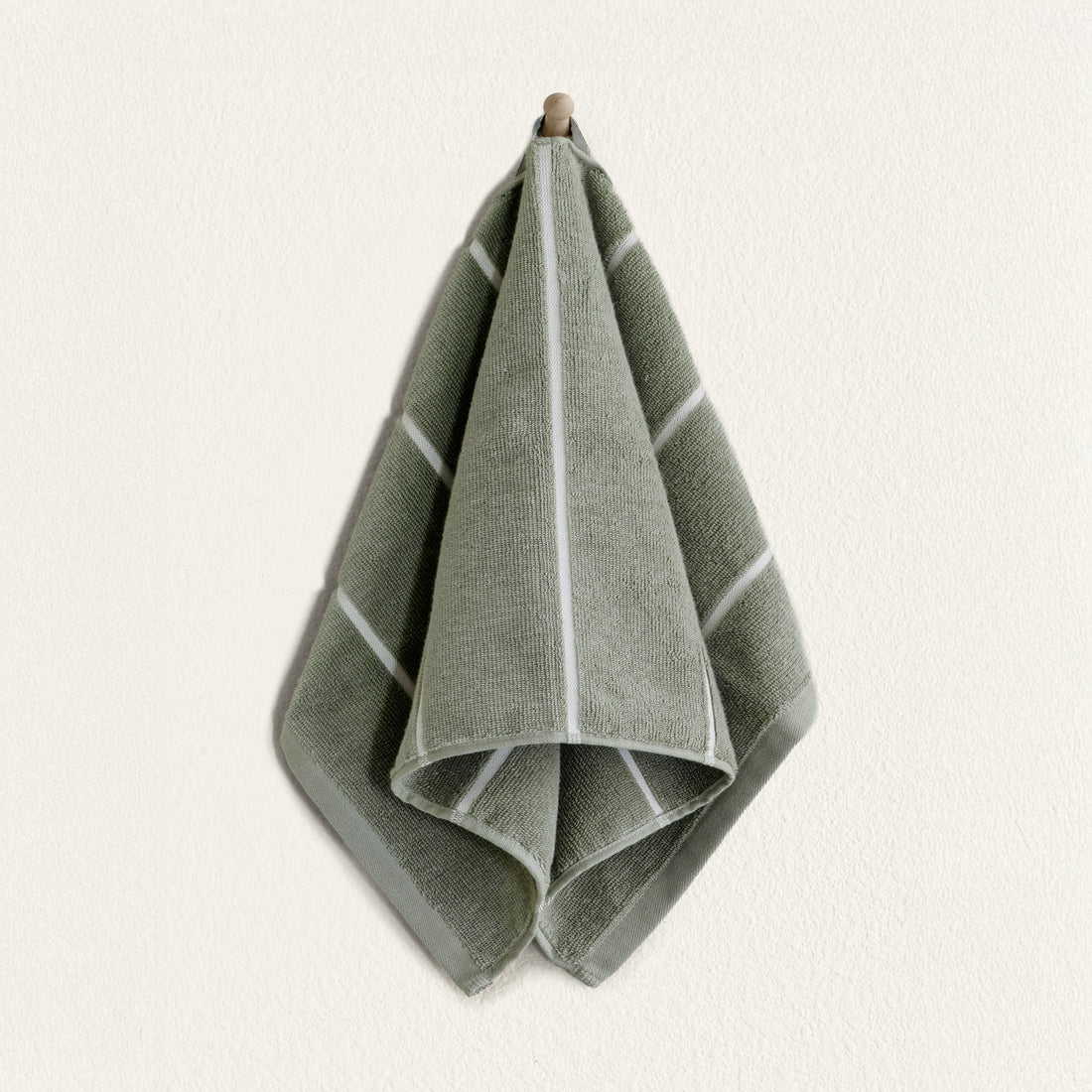 Soft white Deia Australian Cotton Towels from Italic, neatly folded on a bed for home use.