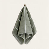 Soft white Deia Australian Cotton Towels from Italic, neatly folded on a bed for home use.