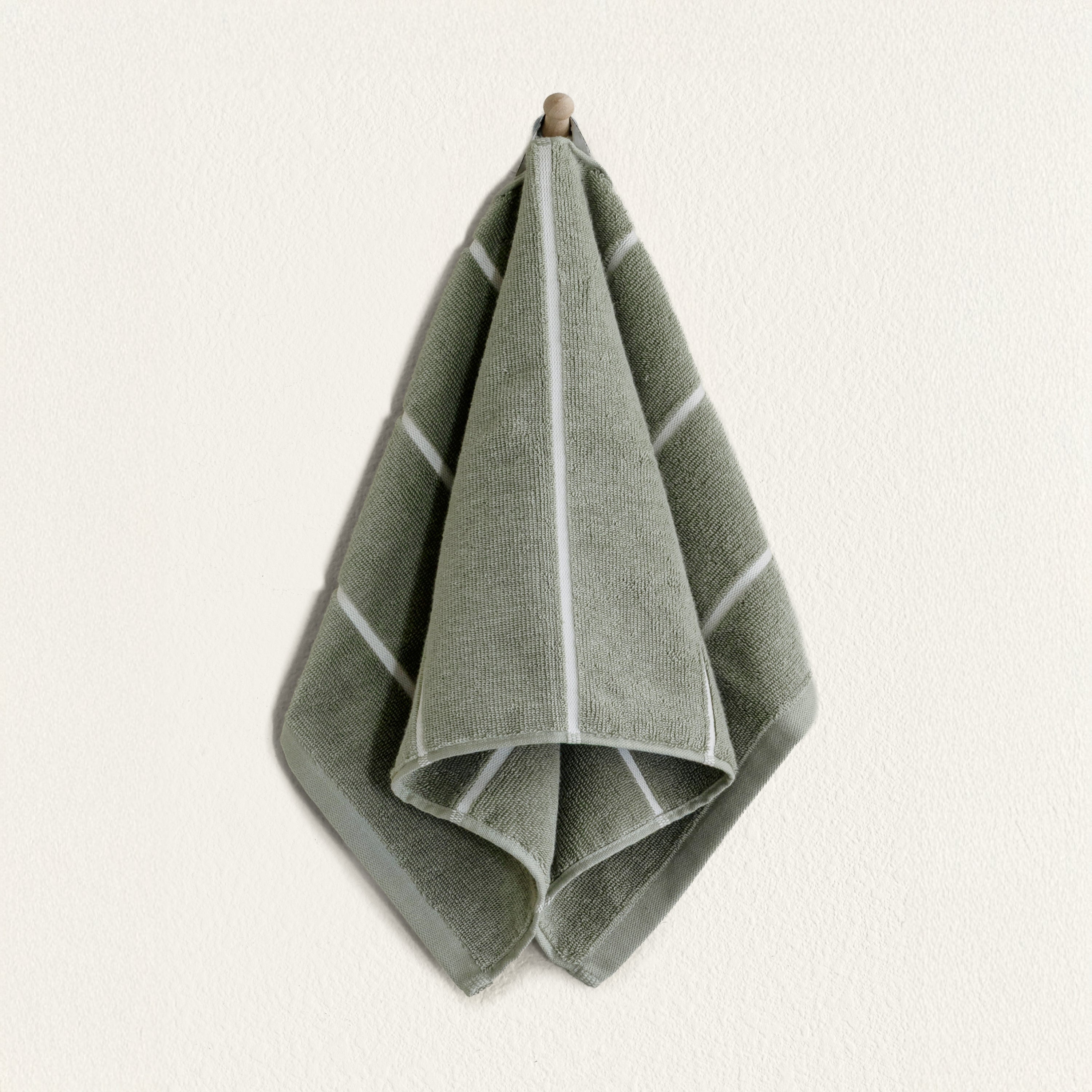 Soft white Deia Australian Cotton Towels from Italic, neatly folded on a bed for home use.