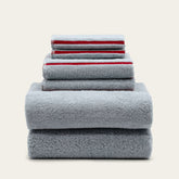 Soft white Deia Australian cotton bath towel from Italic, displayed on a bed with a textured weave and plush appearance.