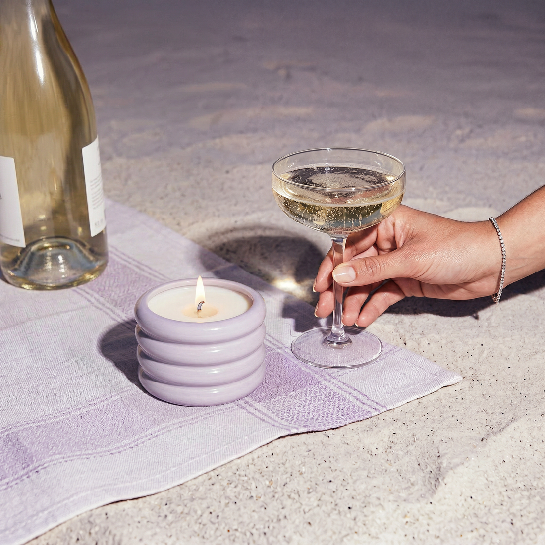 Italic soy wax ceramic candle in lilac color with a smooth ceramic container, set outdoors with natural light.