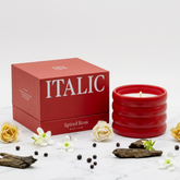 Italic soy wax ceramic candle in a white ceramic holder with a burning wick and soft glow.