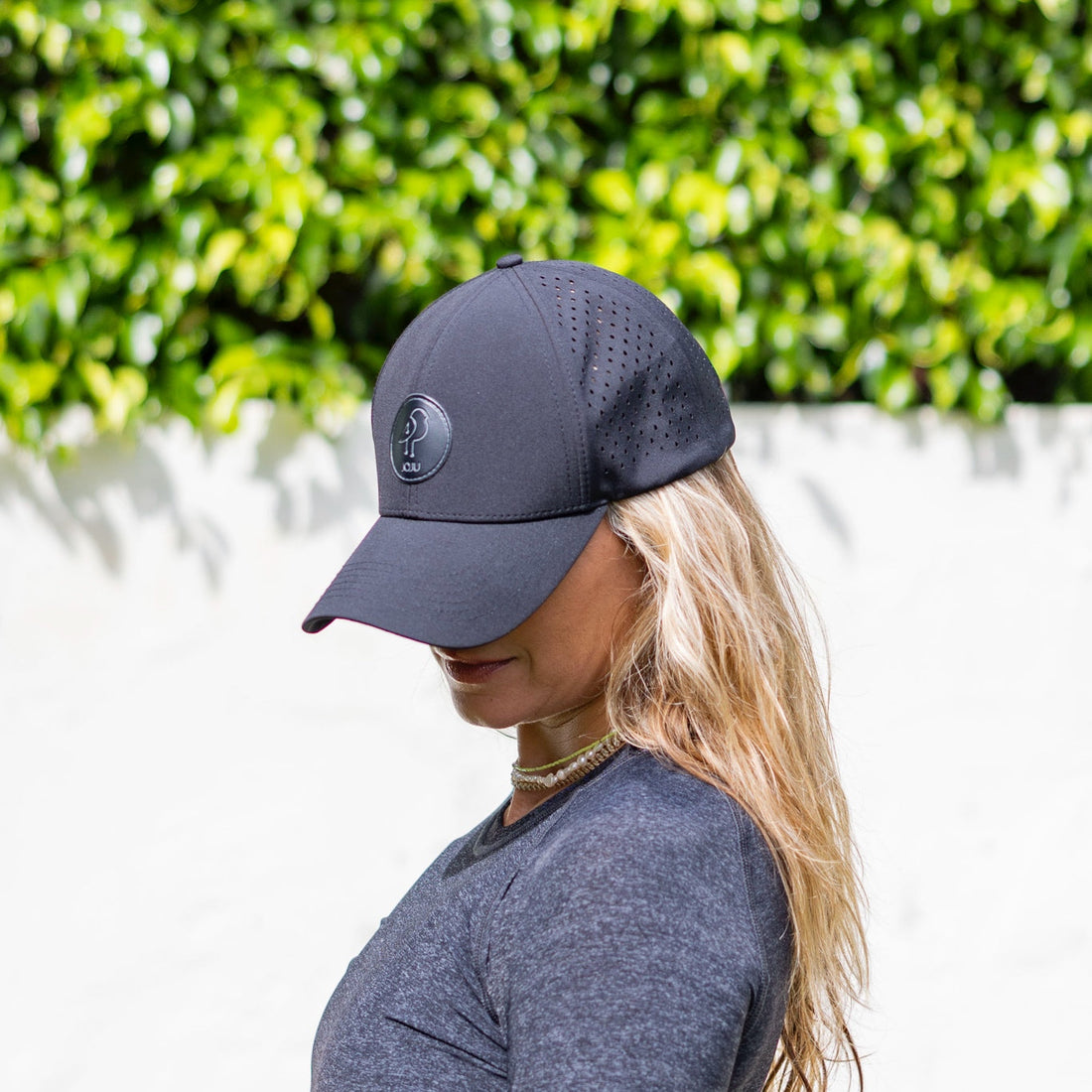 Black JOJU Performance UV Protective Sport Cap shown from front, highlighting its sleek design and adjustable strap.