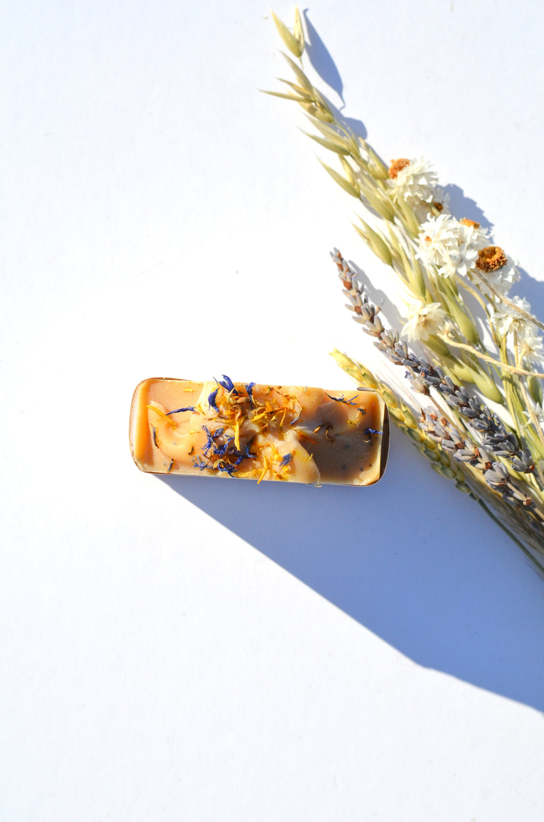 Handmade Lemon, Honey, and Poppy Seed Goat Milk Soap Bar by Pretty Farm Girl, showing the soap with lemon slices and poppy seeds on top.