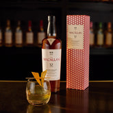A 750ml bottle of The Macallan 12 Year Old Double Cask Single Malt Scotch Whiskey, with a dark brown label and elegant packaging.