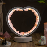 Rose quartz heart-shaped night light by Conscious Items, Love Magnet, emitting a soft glow and featuring a smooth, polished surface.