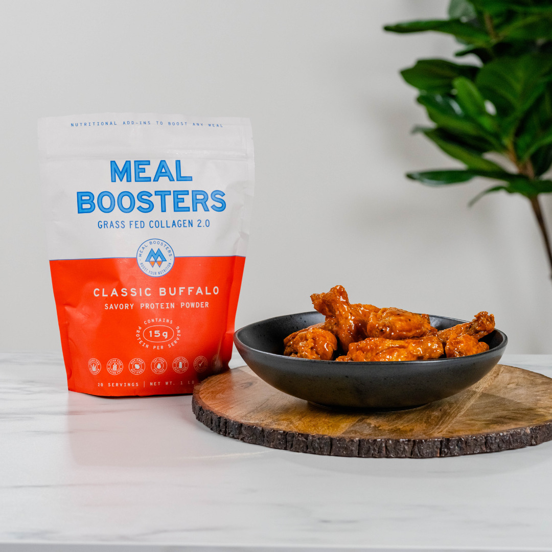 Meal Boosters Classic Buffalo Collagen+ Protein Blend powder container with scoop, showing the product label and branding.
