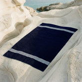 Nautilus Australian Cotton Bath Towel by Italic, soft and plush white towel hanging on a hook in a bathroom.