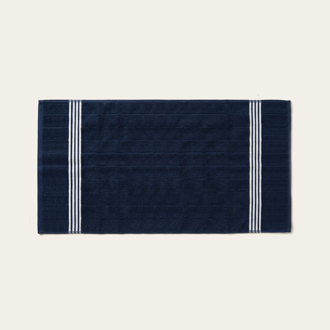 Nautilus Australian Cotton Bath Towel by Italic, soft and plush, draped on a bathroom hook with a folded towel on a clean white background.