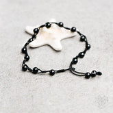 Black obsidian grounding anklet with small beads and adjustable chain, designed for spiritual balance and stylish jewelry.