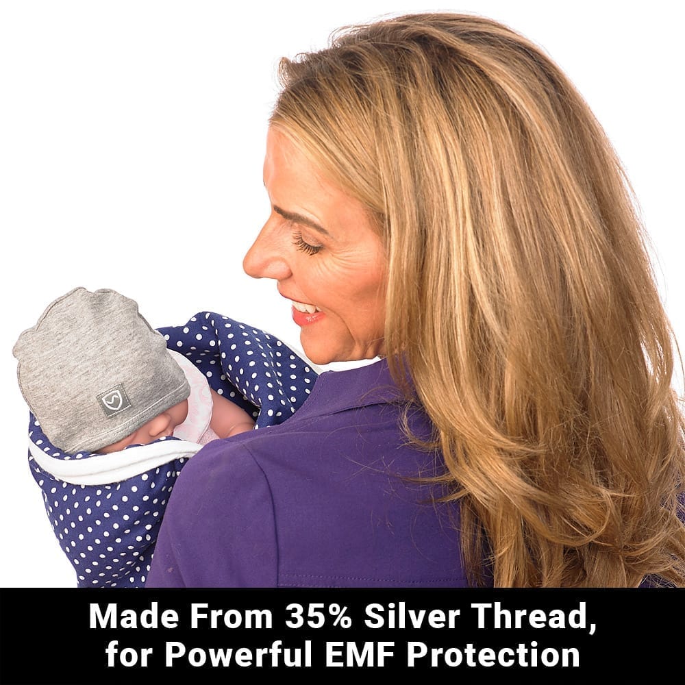 Blue baby beanie from Shield Your Body, designed for infants and toddlers, shown with a soft blanket in the background.