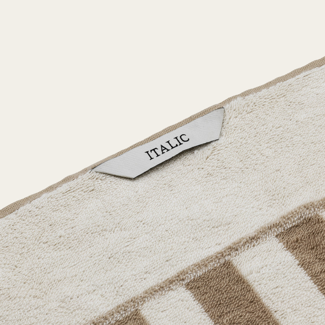 Pietra Australian Cotton Bath Sheet by Italic, soft and plush white cotton towel draped on a bathroom hook.