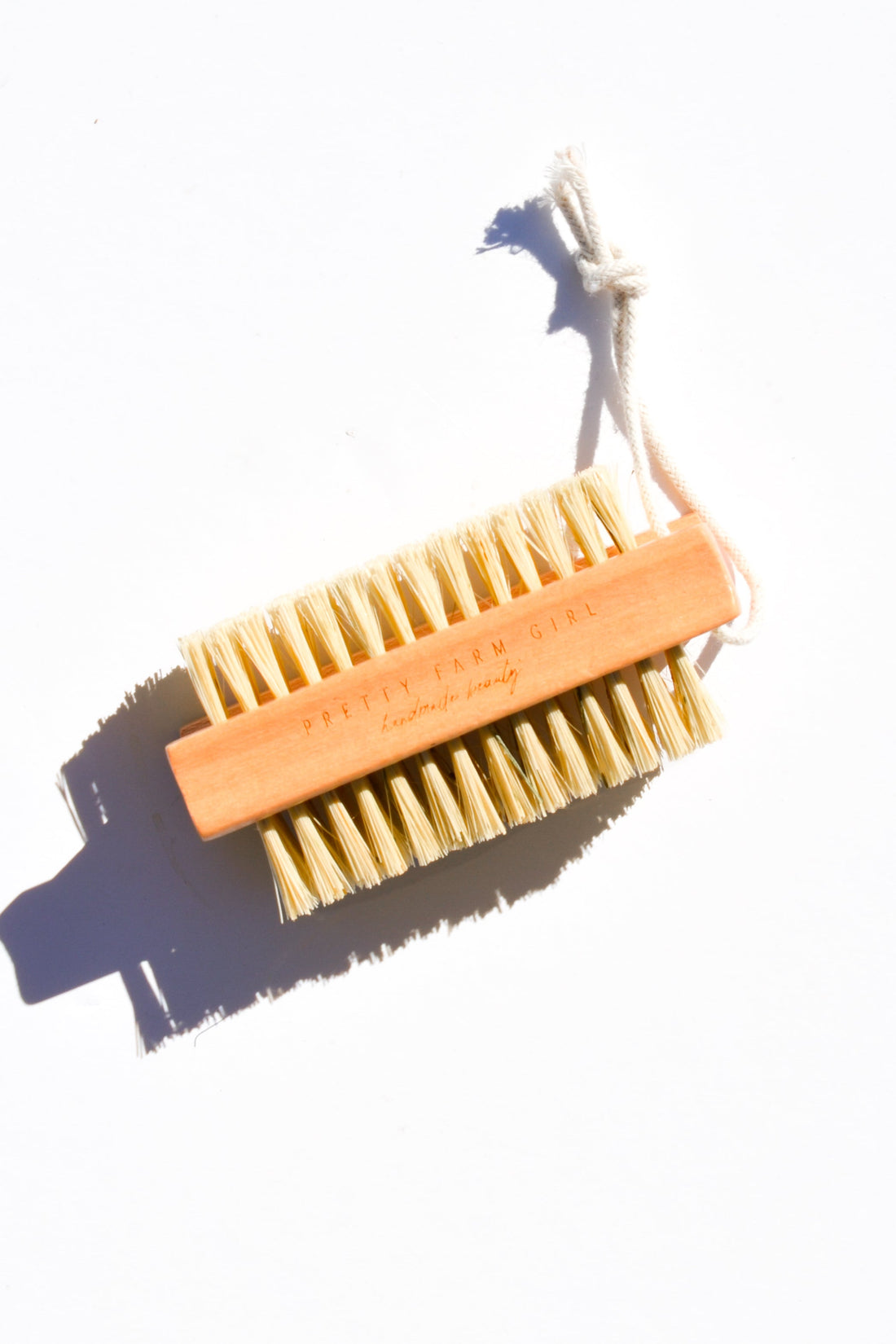 Pretty Farm Girl bamboo nail brush with sisal bristles, showcasing natural wooden handle and textured bristles for cleaning nails.