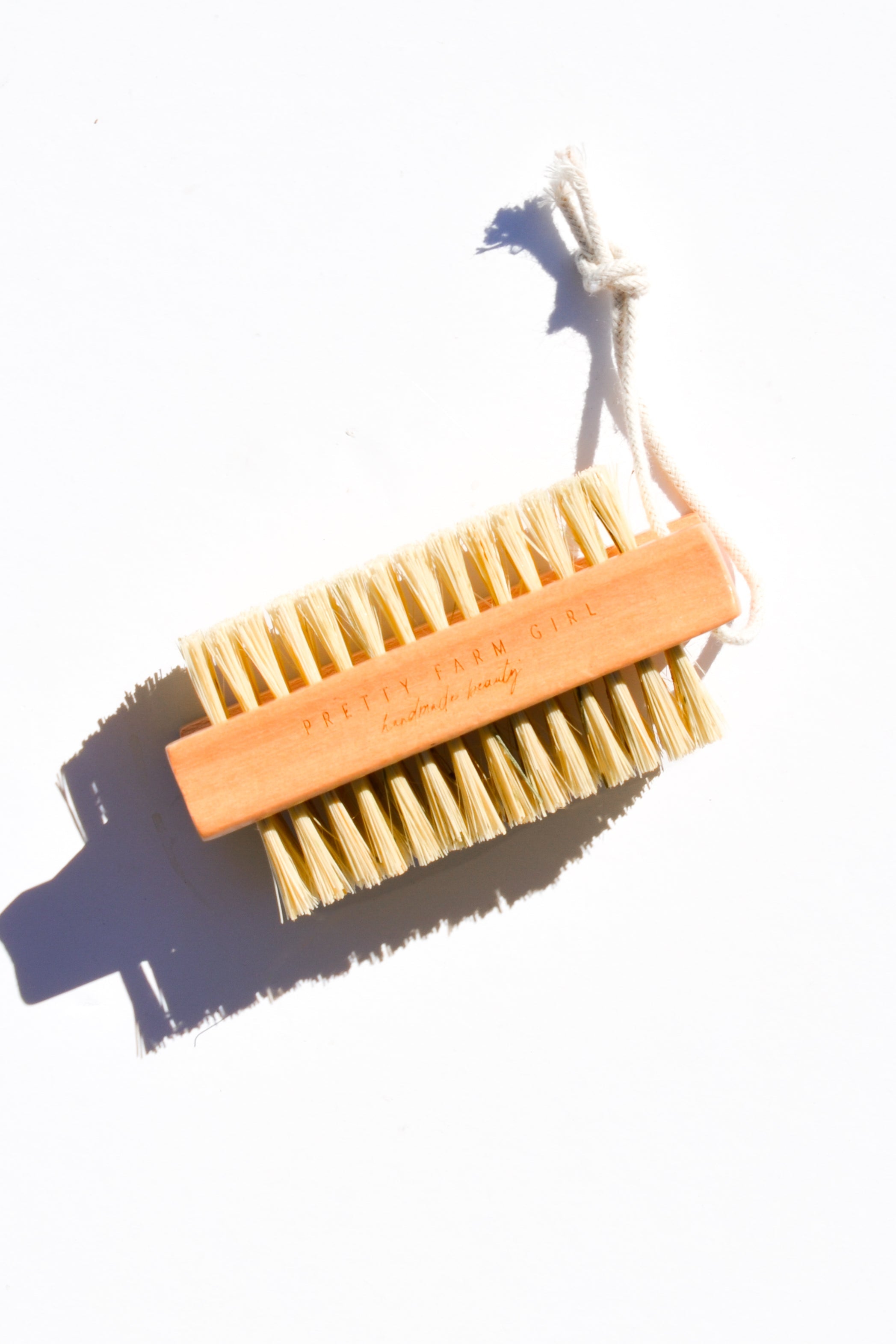 Pretty Farm Girl bamboo nail brush with sisal bristles, showcasing natural wooden handle and textured bristles for cleaning nails.