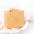 Handmade lemon, honey, and poppy seed goat milk soap bar by Pretty Farm Girl, featuring a natural, textured soap with lemon slices.