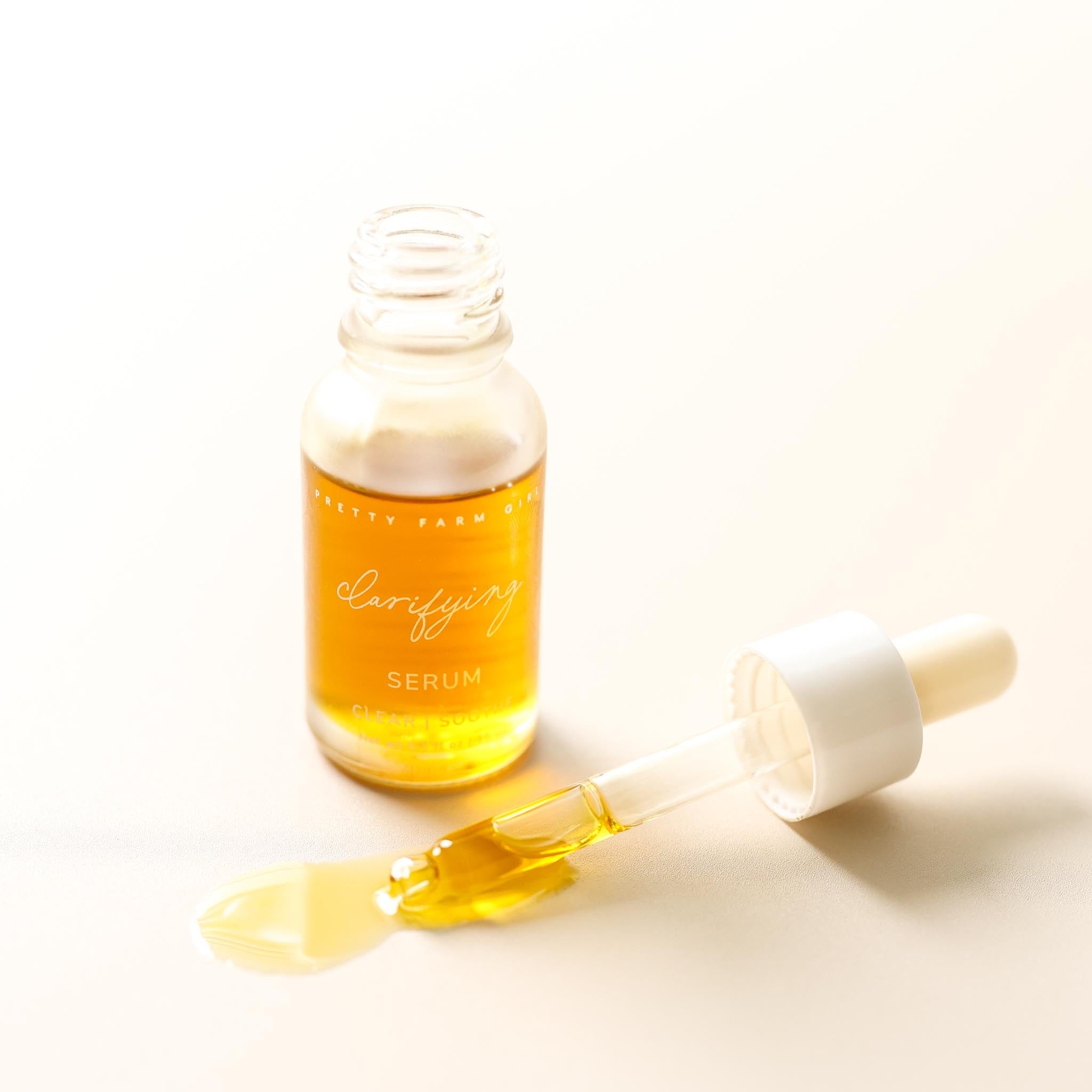 Clear face serum for acne-prone skin by Pretty Farm Girl, featuring a dropper bottle with serum inside.