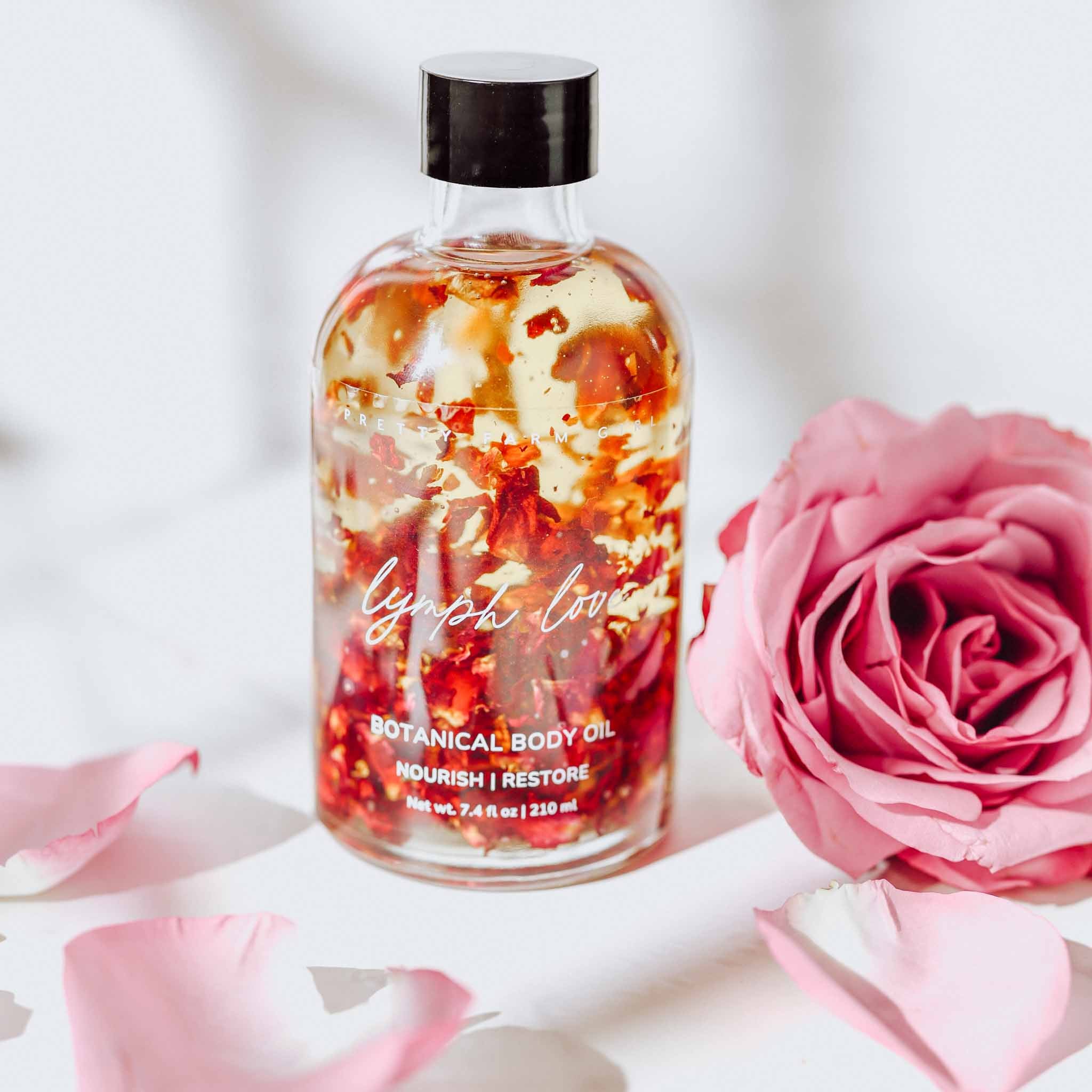 Pretty Farm Girl Lymph Love Body Oil for Massage, health and beauty product, showing a bottle with herbal ingredients and massage application.
