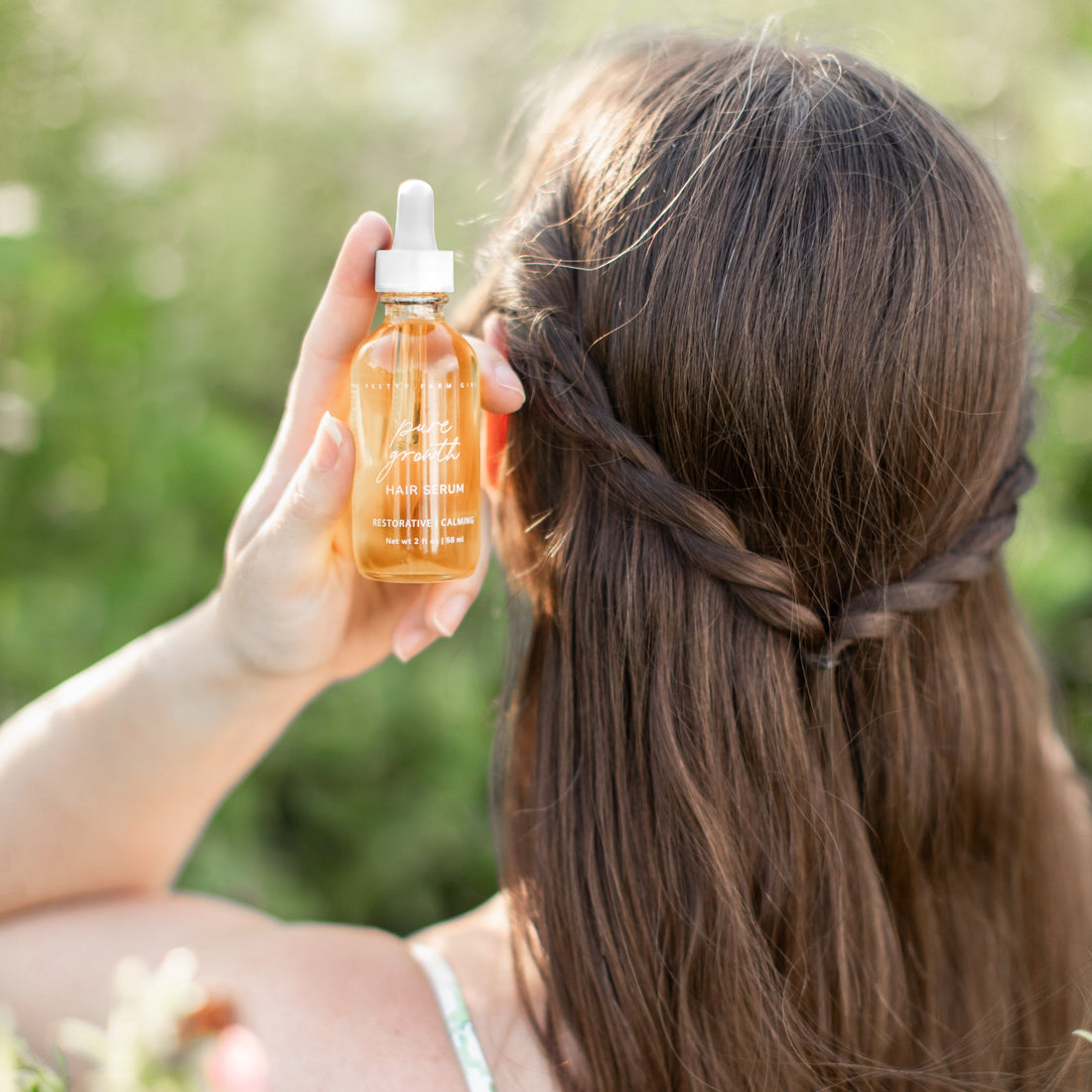 Pretty Farm Girl Pure Growth Hair Serum scalp and hair oil in a white bottle, showcasing smooth, healthy hair and nourishing oil.