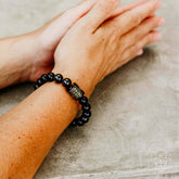Rainbow Obsidian Protection Bracelet from Conscious Items, featuring colorful polished stones on a stretch cord.