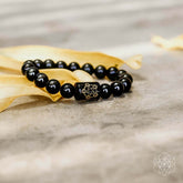 Rainbow Obsidian Protection Bracelet by Conscious Items featuring multicolored polished stones on an elastic band.