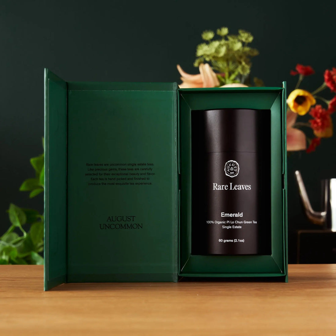 Open luxury tea gift set by August Uncommon Tea featuring rare leaf blends in an emerald box.