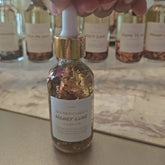 Rich Bitch Conjure Honey Luxe Conjure Oil, a luxurious hoodoo oil blend for love and prosperity, shown in a dark glass bottle.