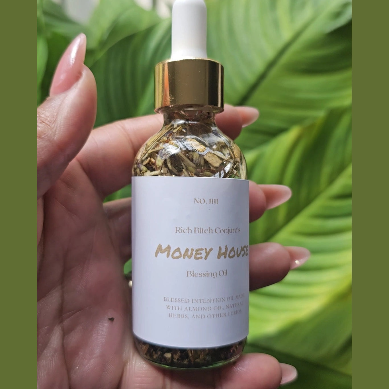 Rich Bitch Conjure Hoodoo oil labeled "Money House Blessing Oil" with a clear glass bottle and black cap, used for spiritual prosperity rituals.