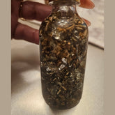 Rich Bitch Conjure Hoodoo oil bottle with label, featuring herbal ingredients and dark packaging for intuitive magic and spiritual work.