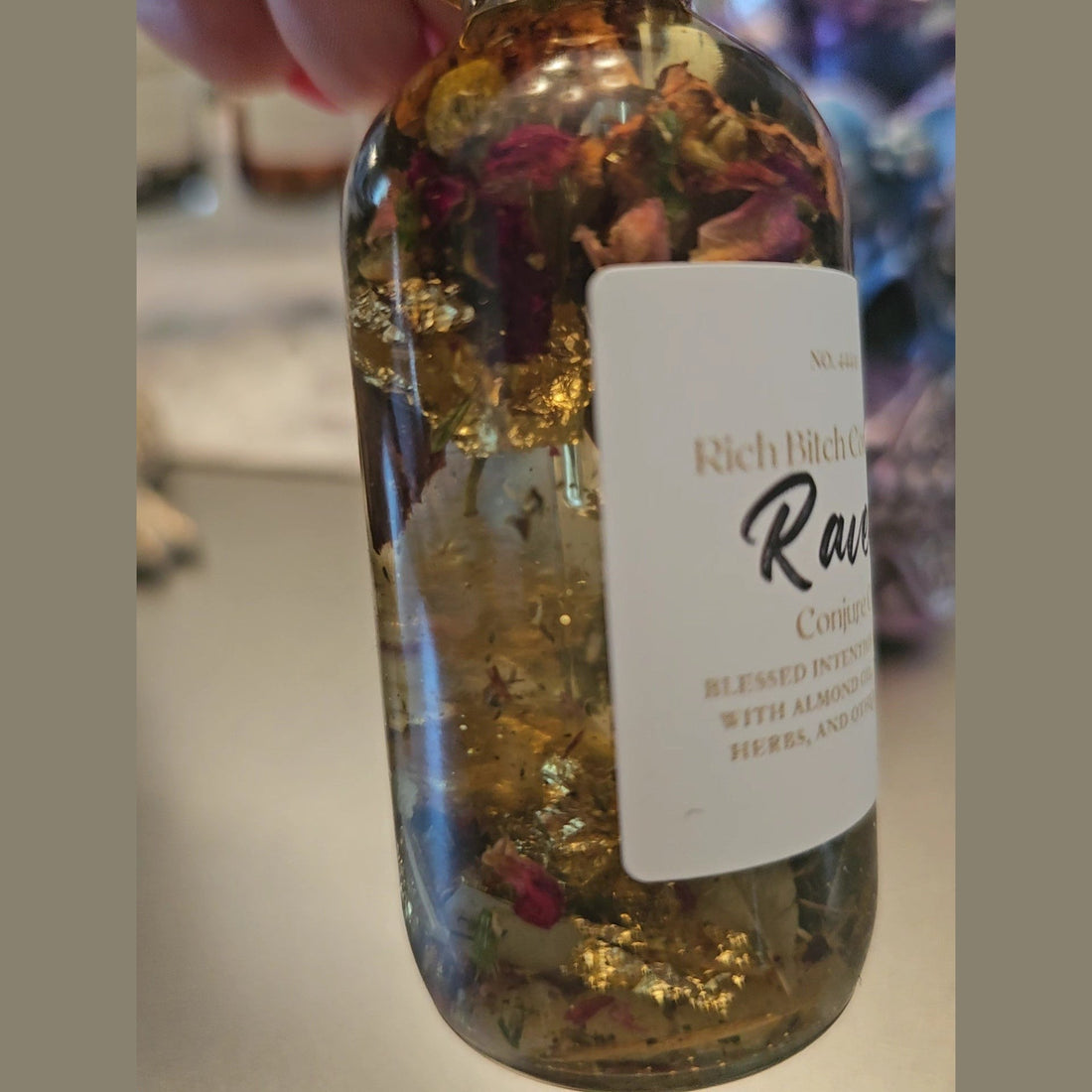 Rich Bitch Conjure Raven Hoodoo Oil for intuition, manifestation, and spiritual power, displayed in a small glass bottle with a black cap.
