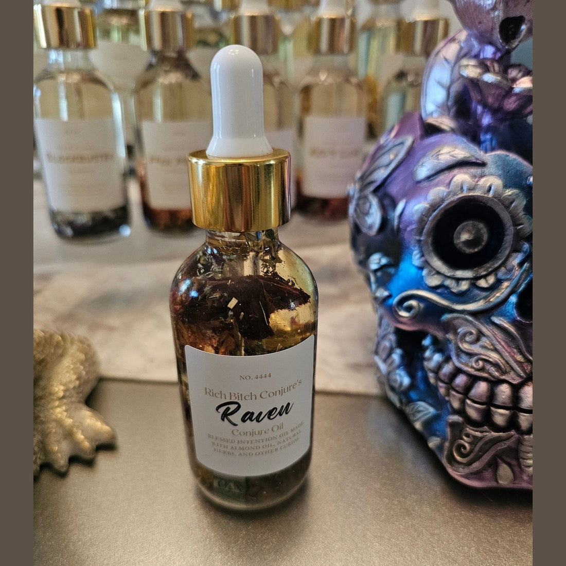 Rich Bitch Conjure Raven Hoodoo Oil for intuition, manifestation, and spiritual power ritual, displayed in a dark glass bottle