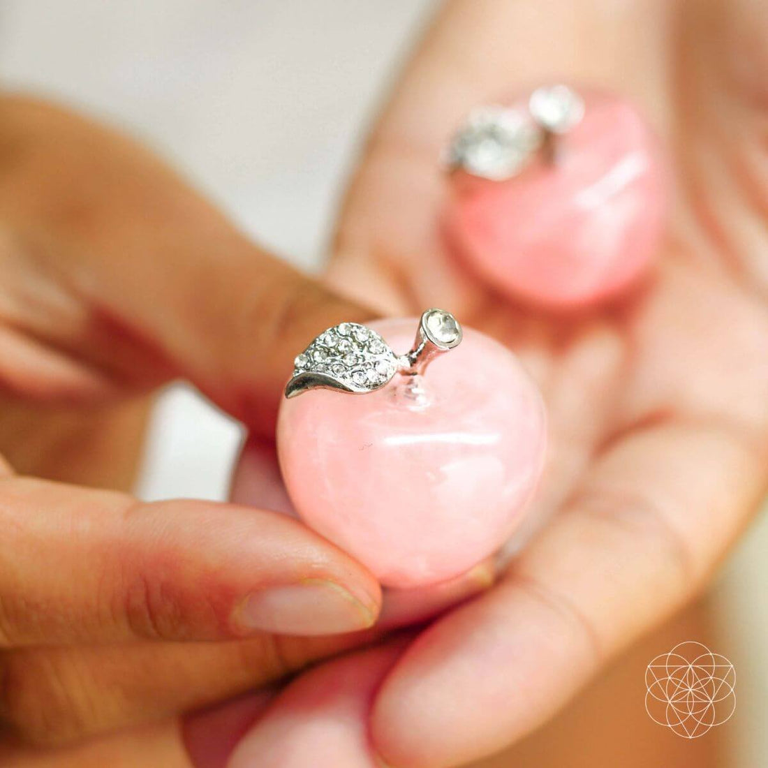 Pair of rose quartz love apples for home decoration by Conscious Items, showcasing polished pink stone sculptures on a neutral background.