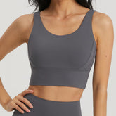Dark gray BLACKOUT BARBELL Omni Bra displayed on a model, showcasing its fit and style for active wear.