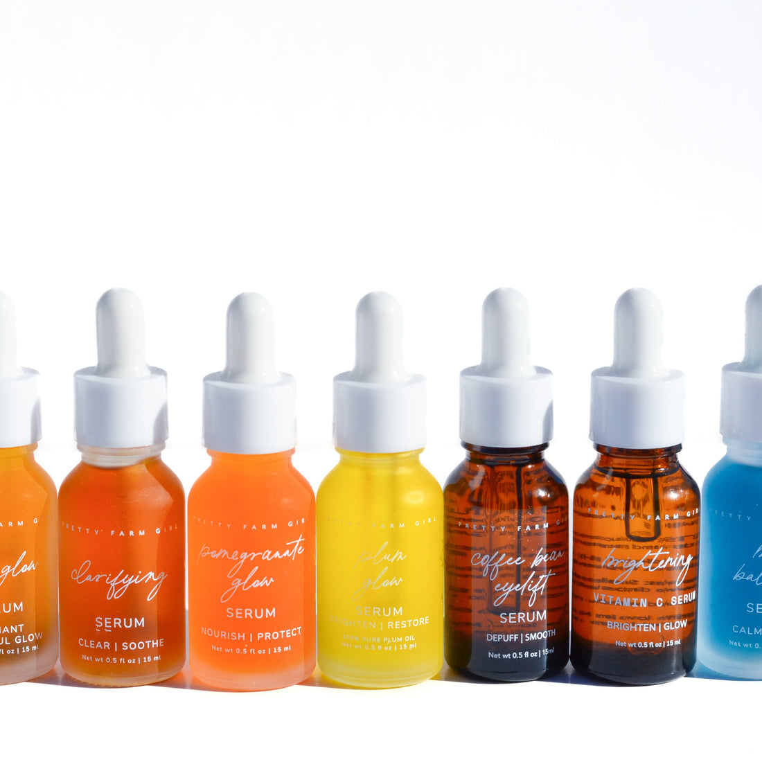 Lineup of Pretty Farm Girl Daily Glow Organic Pressed Nourishing Face Serums in glass bottles with dropper caps.