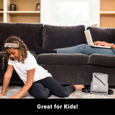 Shield Your Body SYB Sling Bag displayed on a living room floor, showcasing its compact design and adjustable strap.