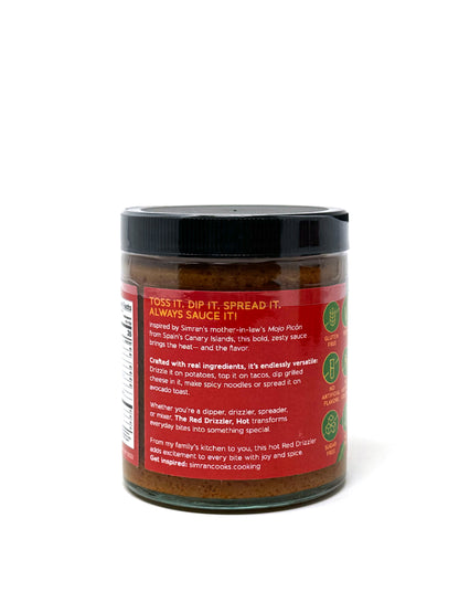 Spicy red Mojo Picón sauce in a jar with a spoon, featuring vibrant red color and the label "The Red Drizzler, HOT" by Simrancooks