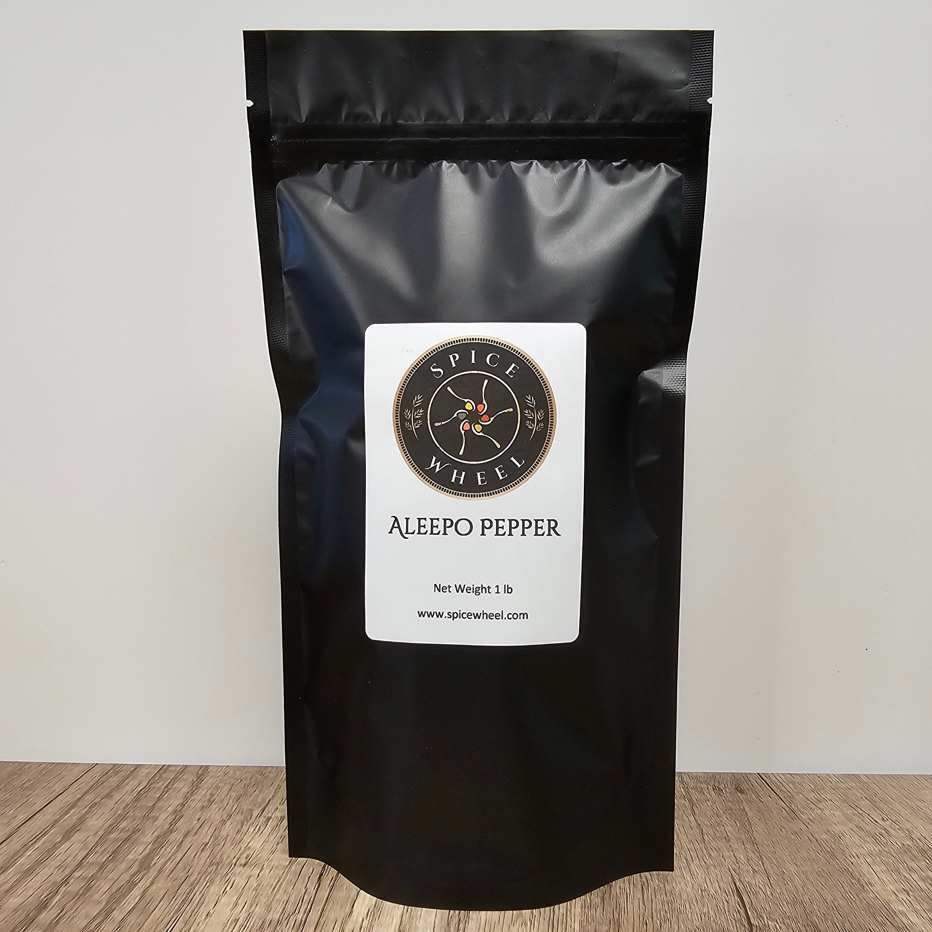 A 1-pound bag of Aleepo Pepper, a bulk spice from Spice Wheel, showing vibrant red dried peppers on the packaging.