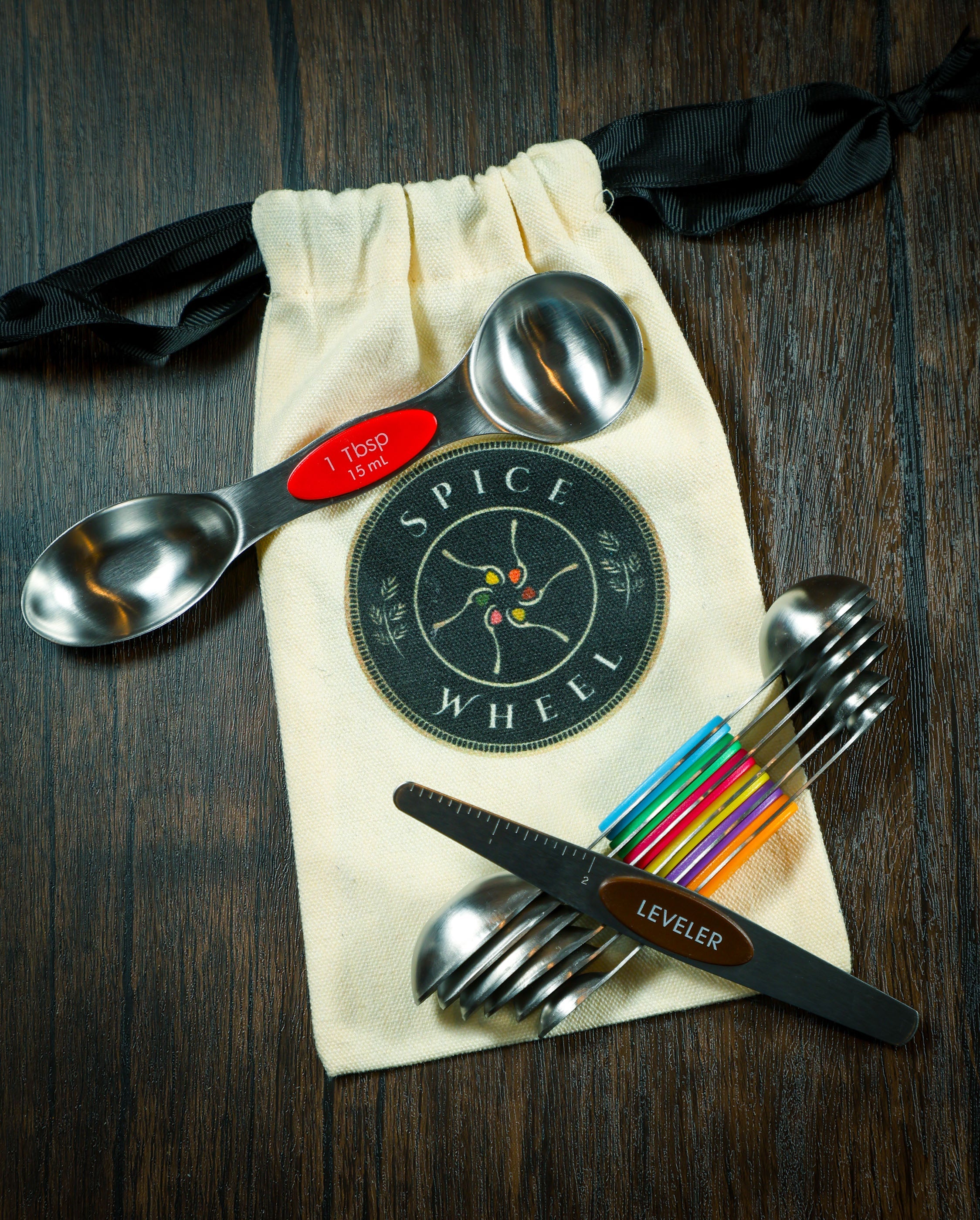 Set of Spice Wheel magnetic spoons with leveler and canvas gift bag, ideal for precise spice measuring and storage.