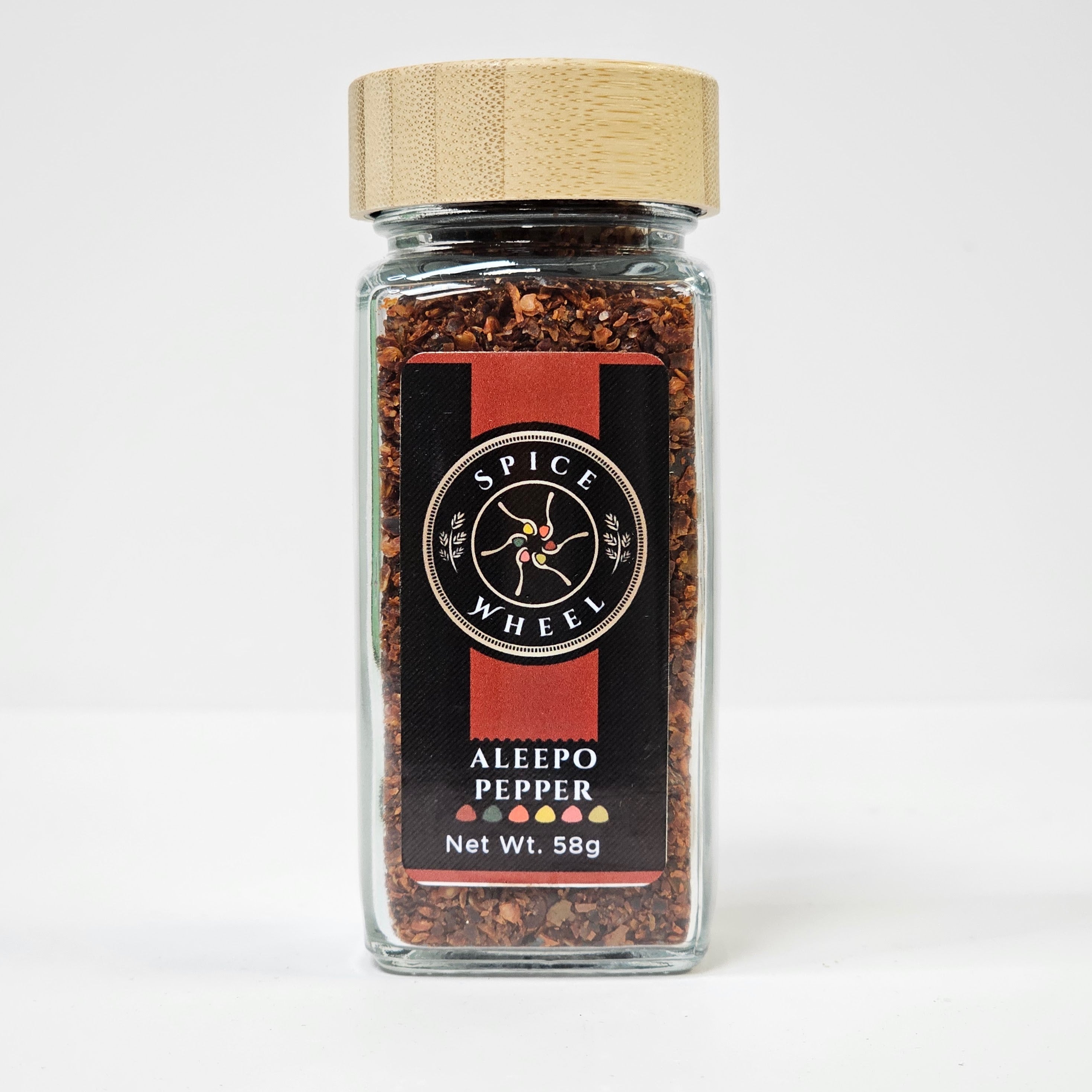 Glass jar of Aleepo Pepper from Spice Wheel, filled with vibrant, whole red peppers in a clear container on a white background.