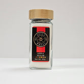 Glass jar of apple sugar from Spice Wheel with a clear label and a metal lid, containing sweet apple-flavored sugar in a compact container.