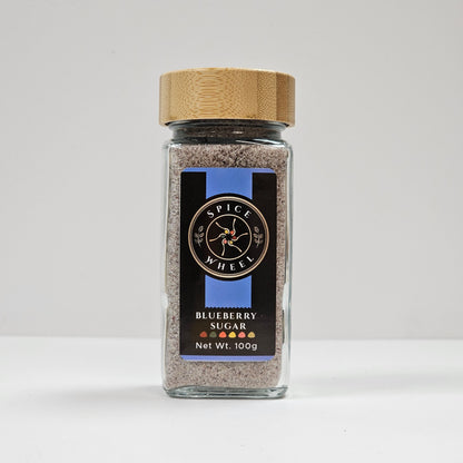 Glass jar of Blueberry Sugar from Spice Wheel, filled with vibrant blue-colored blueberry-flavored sugar for baking and cooking.